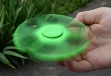 Un hand spinner vert en mouvement.