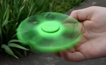 Un hand spinner vert en mouvement.