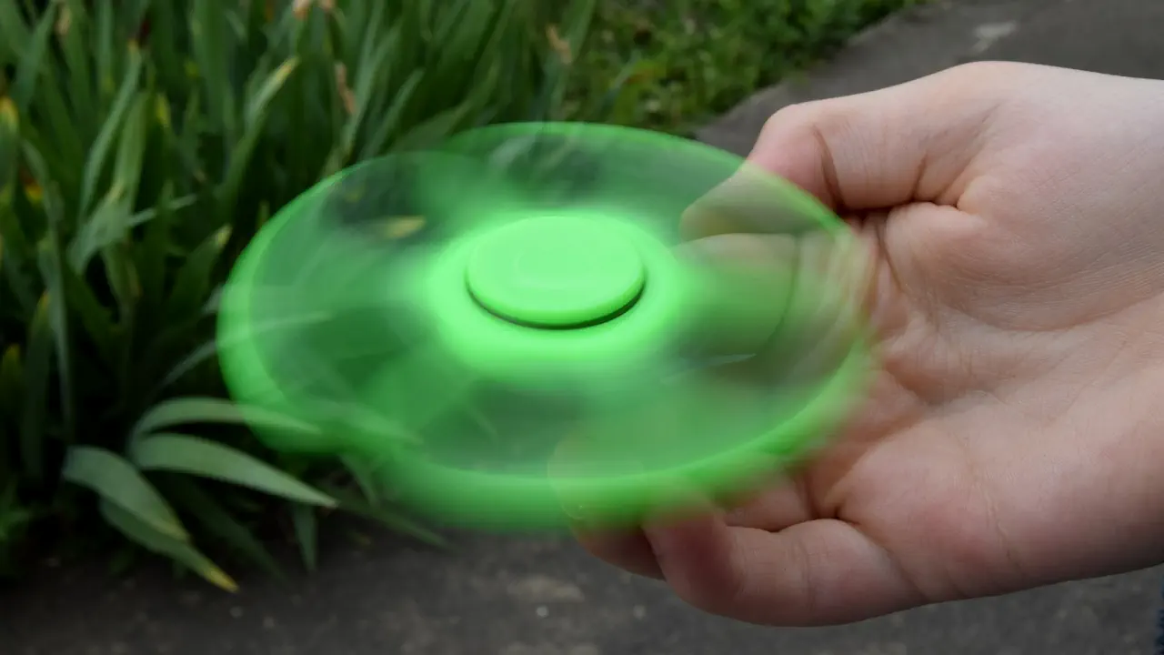 Un hand spinner vert en mouvement.