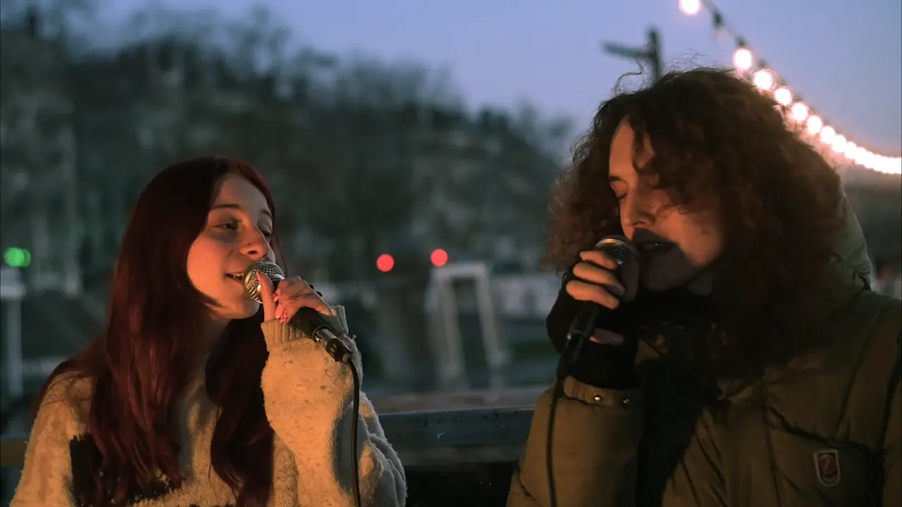 Marius et Mina, couple à la ville comme sur scène, forment le cœur du duo Candeur Cyclone. Leur alchimie artistique, portée par un dialogue vocal égalitaire et intense, captive le public à chaque performance.