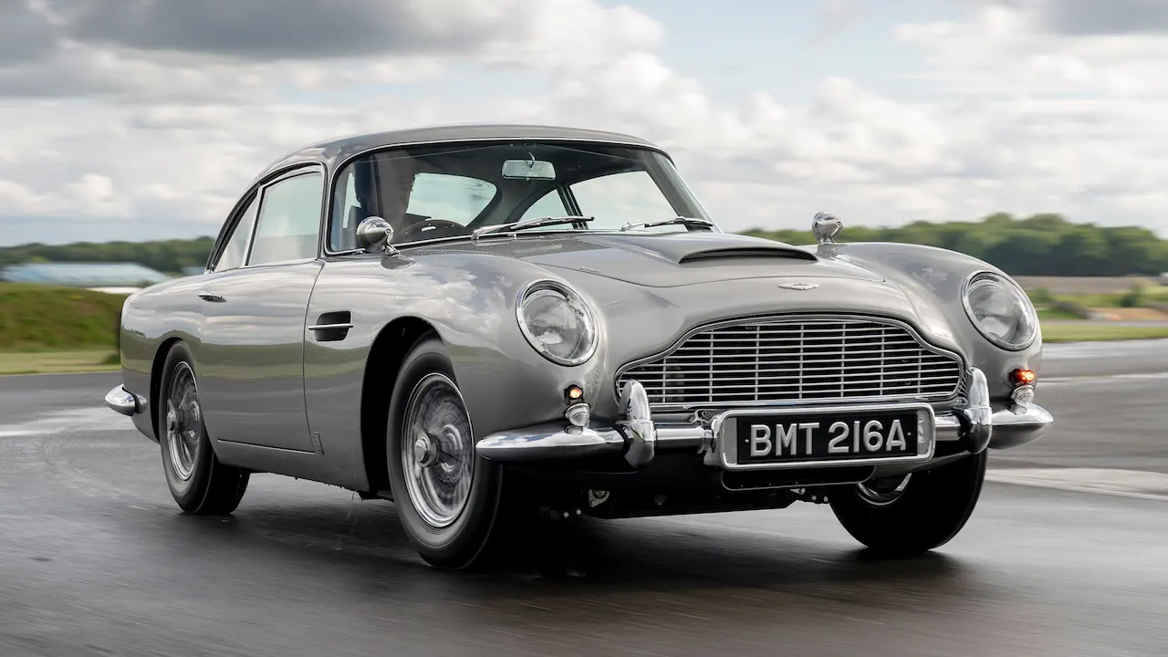 La Aston Martin DB5 (Goldfinger) est une voiture iconique du cinéma devenue indissociable de James Bond dès sa première apparition. Équipée de gadgets spectaculaires, cette voiture mythique du cinema associe élégance britannique et espionnage.