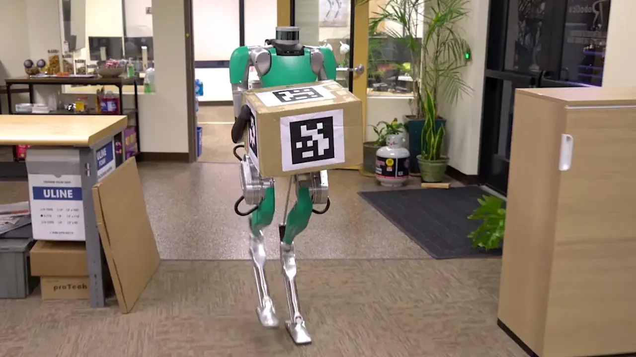 Le robot humanoïde Digit, développé par Agility Robotics, est conçu pour des applications logistiques avec une intégration concrète en entrepôt. Grâce à sa locomotion bipède stable, il peut transporter des colis et évoluer dans des environnements adaptés aux humains.